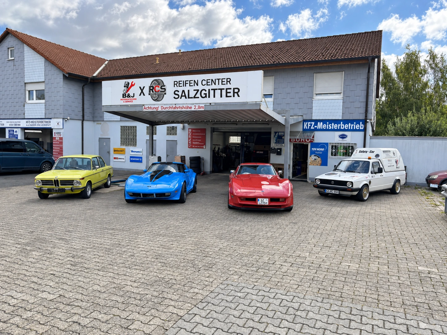 BMW und zwei Corvette-Oldtimer vor dem Reifen-Center Salzgitter – Gesamtansicht